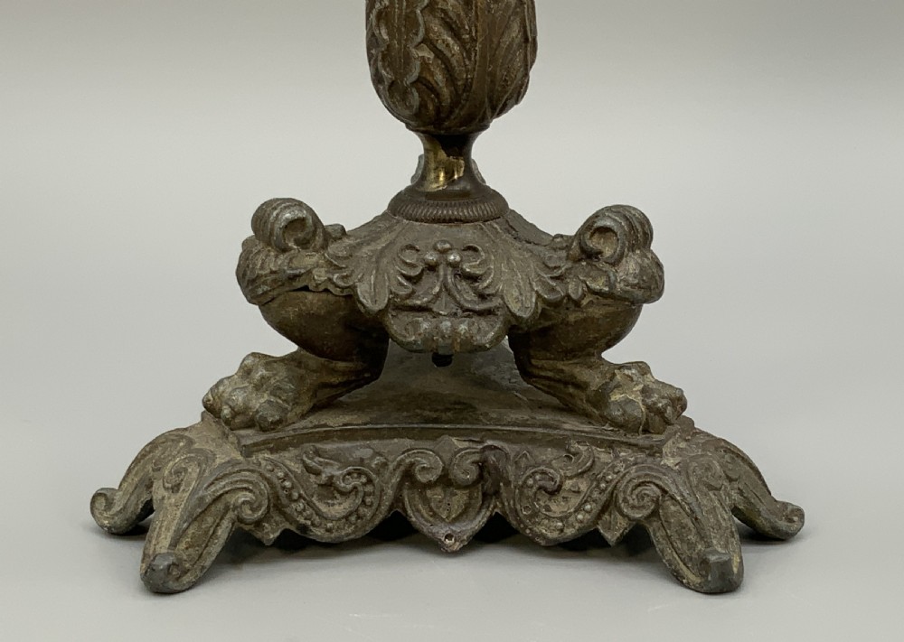 A pair of nineteenth-century French Empire metal candlesticks featuring dark tapered columns, ornate acanthus leaf capitals, and decorative triangular bases. View XI