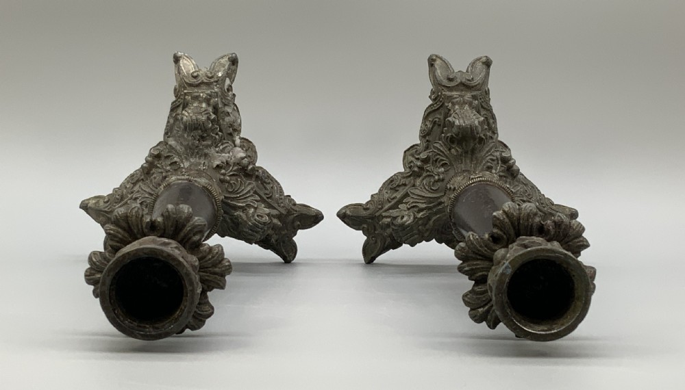 A pair of nineteenth-century French Empire metal candlesticks featuring dark tapered columns, ornate acanthus leaf capitals, and decorative triangular bases. View XIII