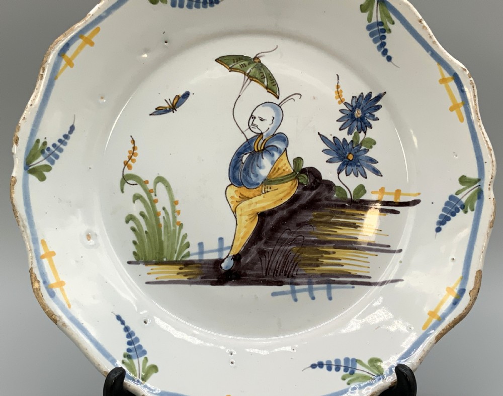 An 18th-century French tin-glazed earthenware charger with a lobed border featuring hand-painted Chinoiserie figures and floral motifs. View III