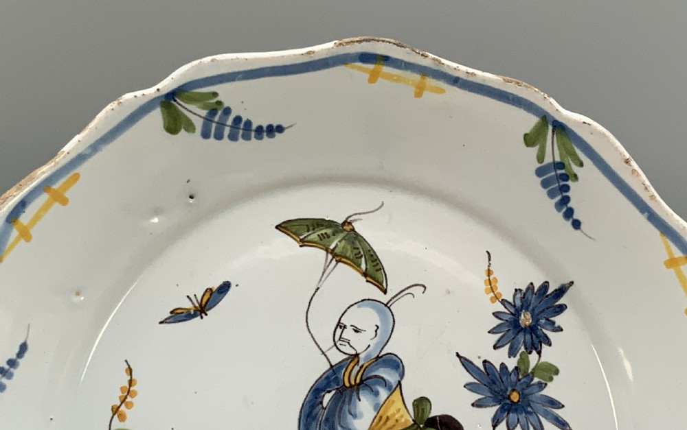 An 18th-century French tin-glazed earthenware charger with a lobed border featuring hand-painted Chinoiserie figures and floral motifs. View IV