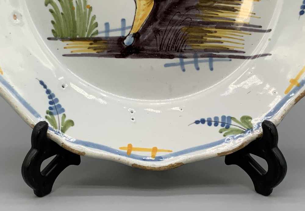 An 18th-century French tin-glazed earthenware charger with a lobed border featuring hand-painted Chinoiserie figures and floral motifs. View V
