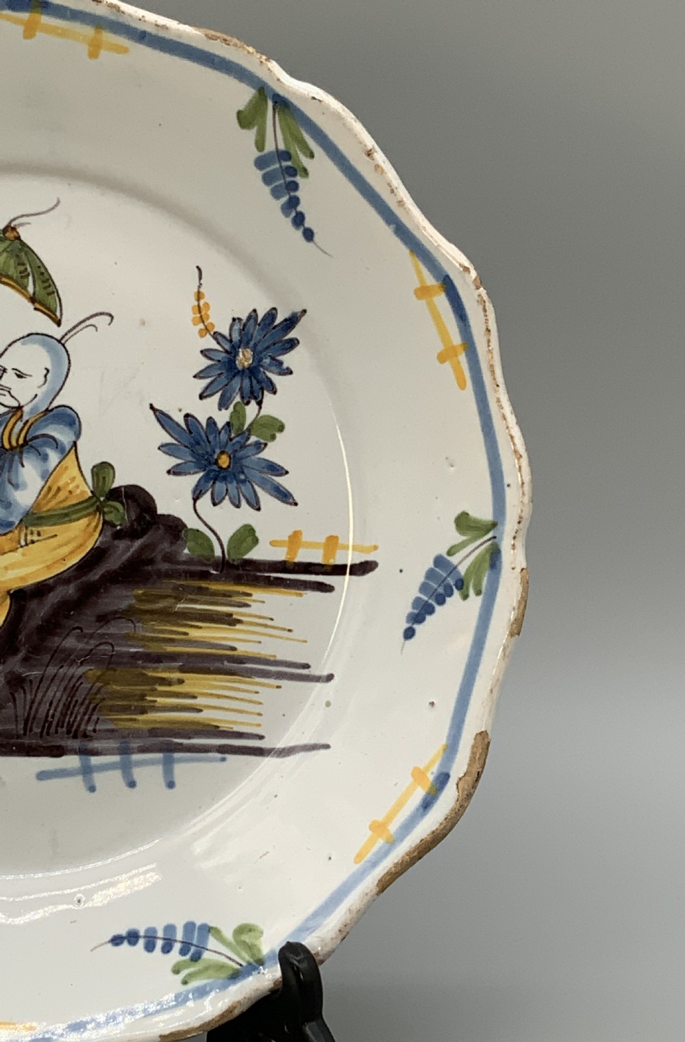 An 18th-century French tin-glazed earthenware charger with a lobed border featuring hand-painted Chinoiserie figures and floral motifs. View VI