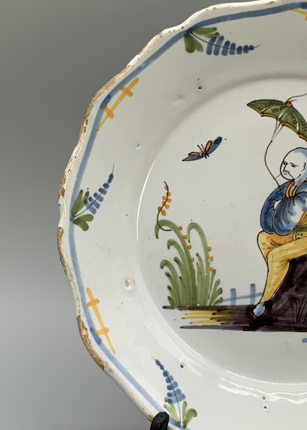 An 18th-century French tin-glazed earthenware charger with a lobed border featuring hand-painted Chinoiserie figures and floral motifs. View VII