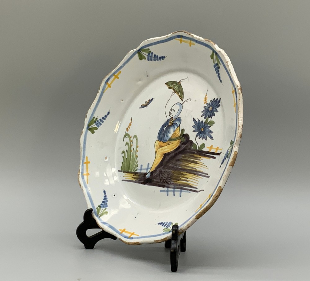 An 18th-century French tin-glazed earthenware charger with a lobed border featuring hand-painted Chinoiserie figures and floral motifs. View IX