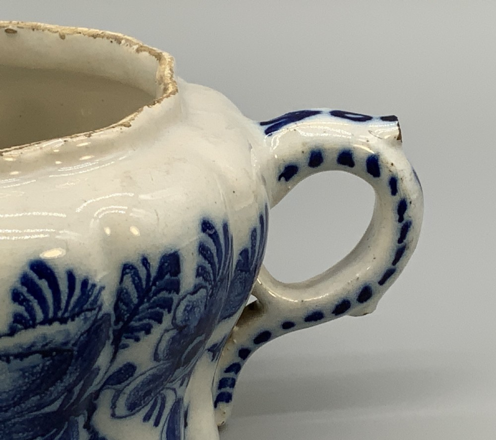 A 17th-century English Delftware lidded pot painted with cobalt blue floral motifs, featuring two side loop handles and a knopped lid. View XII