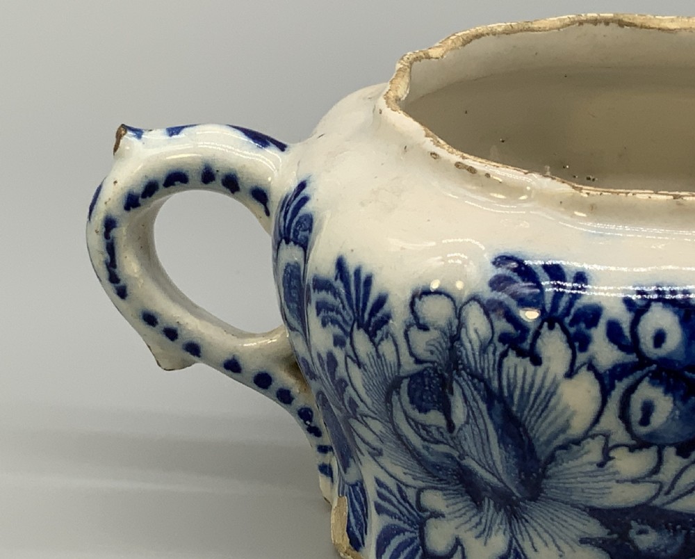 A 17th-century English Delftware lidded pot painted with cobalt blue floral motifs, featuring two side loop handles and a knopped lid. View XIII
