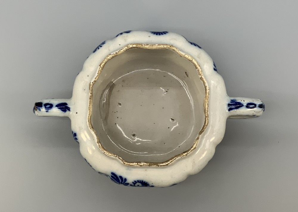 A 17th-century English Delftware lidded pot painted with cobalt blue floral motifs, featuring two side loop handles and a knopped lid. View XV