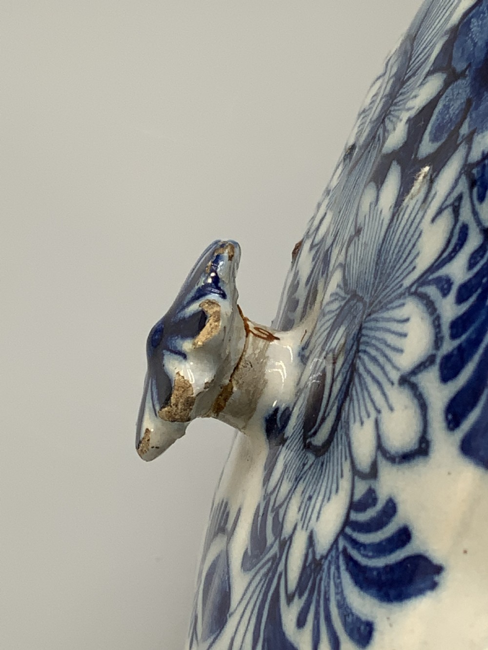 A 17th-century English Delftware lidded pot painted with cobalt blue floral motifs, featuring two side loop handles and a knopped lid. View XX