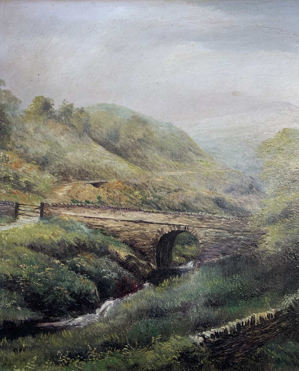 A 19th-century Victorian oil painting depicting a British rural landscape with a stone arch bridge, framed in an ornate gilded wooden frame. View VII