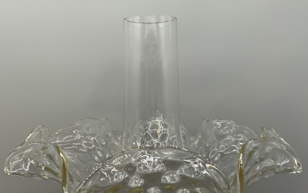 An Art Nouveau table oil lamp featuring a black ceramic base, cast brass stem, clear glass reservoir, double wick burner, clear chimney, and ruffled glass shade. View IV