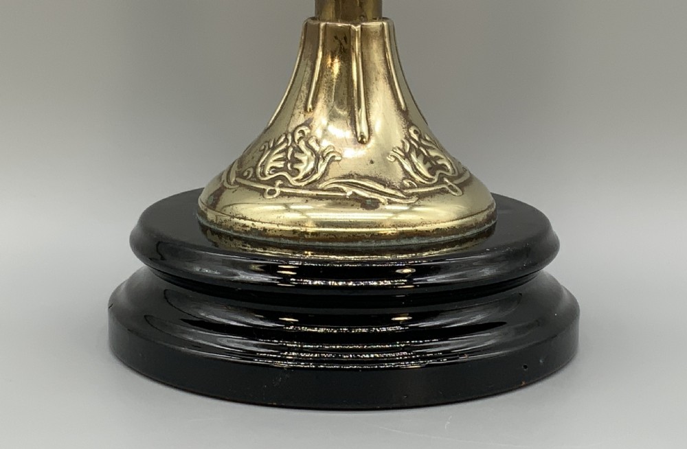 An Art Nouveau table oil lamp featuring a black ceramic base, cast brass stem, clear glass reservoir, double wick burner, clear chimney, and ruffled glass shade. View VII