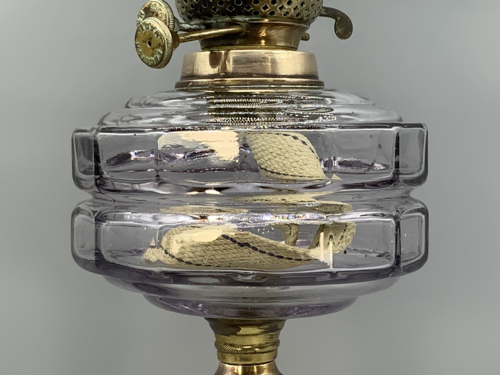 An Art Nouveau table oil lamp featuring a black ceramic base, cast brass stem, clear glass reservoir, double wick burner, clear chimney, and ruffled glass shade. View VIII
