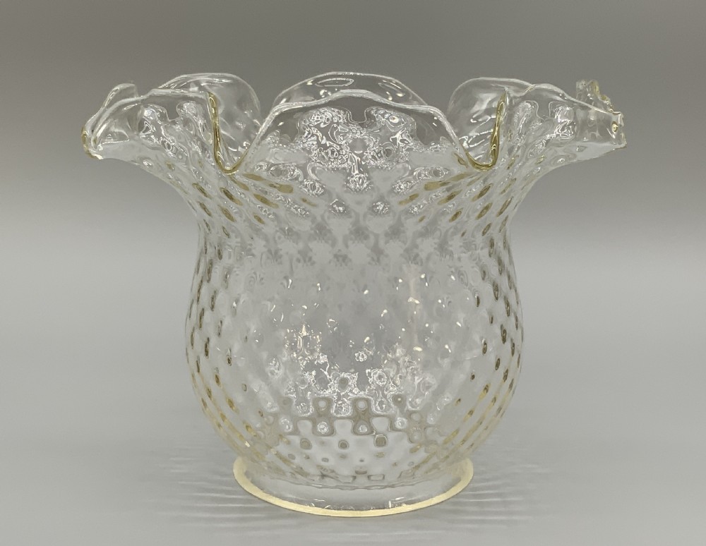 An Art Nouveau table oil lamp featuring a black ceramic base, cast brass stem, clear glass reservoir, double wick burner, clear chimney, and ruffled glass shade. View XIII