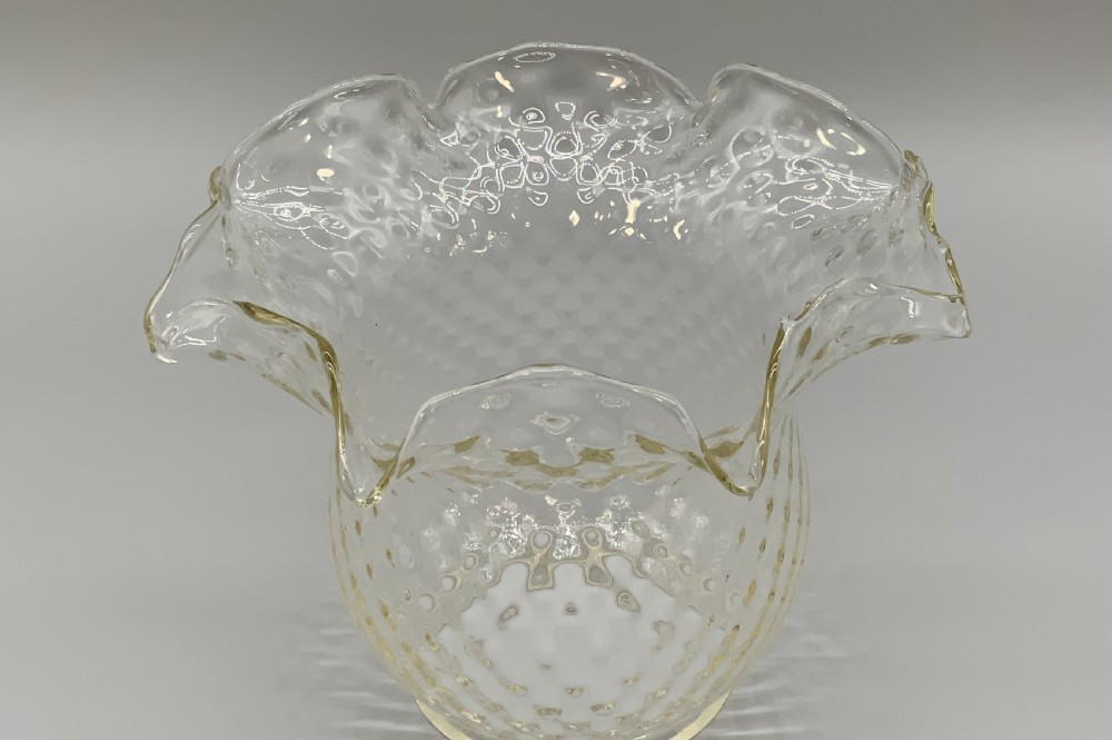 An Art Nouveau table oil lamp featuring a black ceramic base, cast brass stem, clear glass reservoir, double wick burner, clear chimney, and ruffled glass shade. View XIV