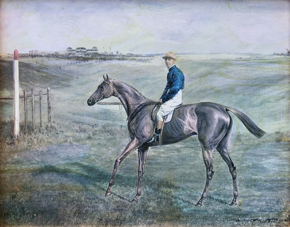 A framed miniature print depicting a jockey in blue silks seated on a dark racehorse in a countryside landscape, enclosed in a moulded timber frame with a gold inner slip. View III
