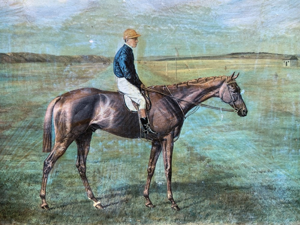 A framed miniature print depicting a jockey in blue silks seated on a dark racehorse in a countryside landscape, enclosed in a moulded timber frame with a gold inner slip. View VIII