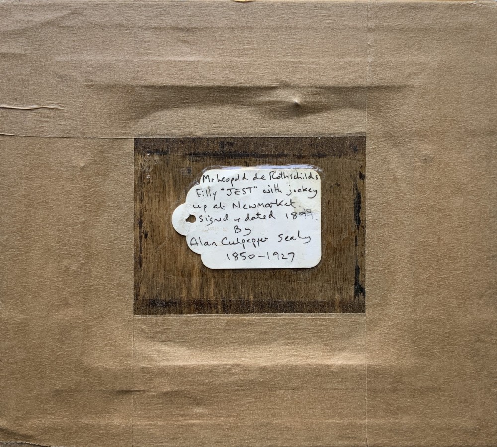 A framed miniature print depicting a jockey in blue silks seated on a dark racehorse in a countryside landscape, enclosed in a moulded timber frame with a gold inner slip. View X