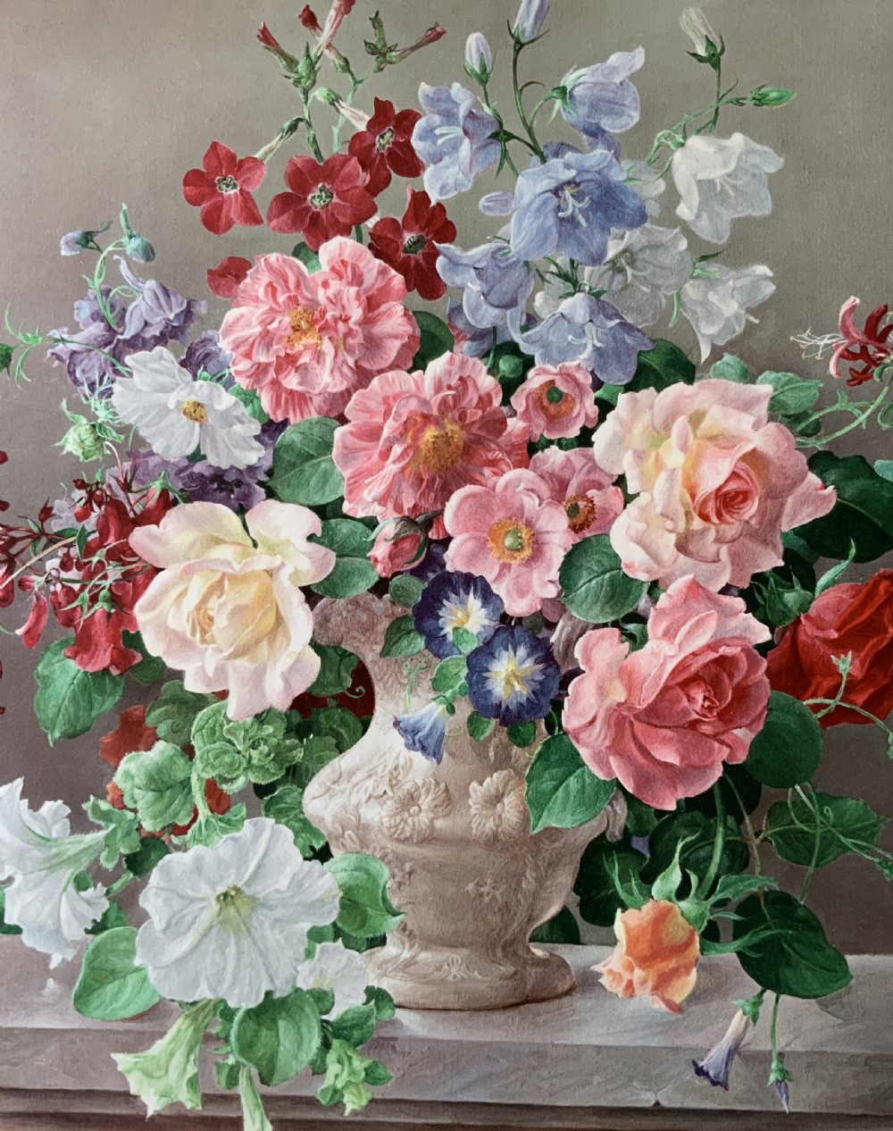 A framed oleograph print depicting a bouquet of pink, red, and blue garden flowers in an ornate ceramic urn on a stone ledge, enclosed within a decorative gilded frame. View VII