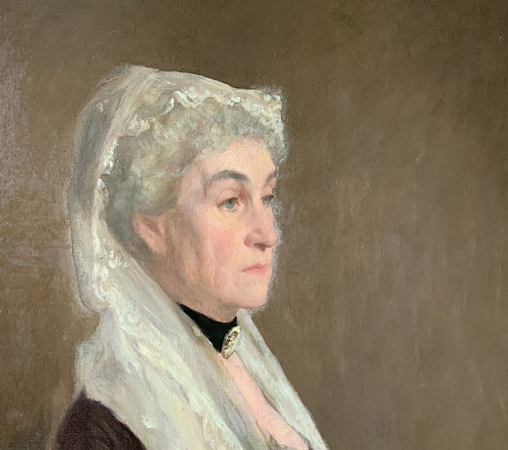 A large framed oil portrait painting on canvas depicting a mature woman wearing a lace head covering and draped red shawl against a dark brown background. View V