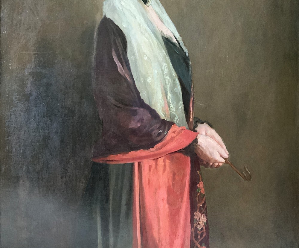 A large framed oil portrait painting on canvas depicting a mature woman wearing a lace head covering and draped red shawl against a dark brown background. View VI