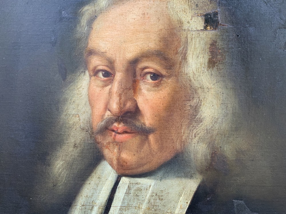 A seventeenth-century oval oil portrait of a gentleman with grey hair wearing a black coat and white collar, housed in a carved gold leaf frame. View IV
