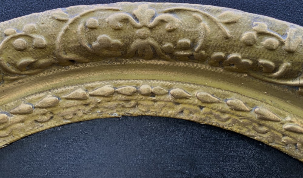 A seventeenth-century oval oil portrait of a gentleman with grey hair wearing a black coat and white collar, housed in a carved gold leaf frame. View X