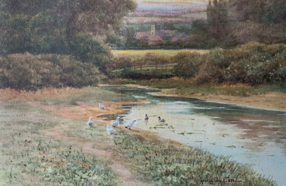 A framed watercolour painting depicting a tranquil river landscape in Buckinghamshire with trees and birds, set inside a gold mount and beaded gilt frame. View V
