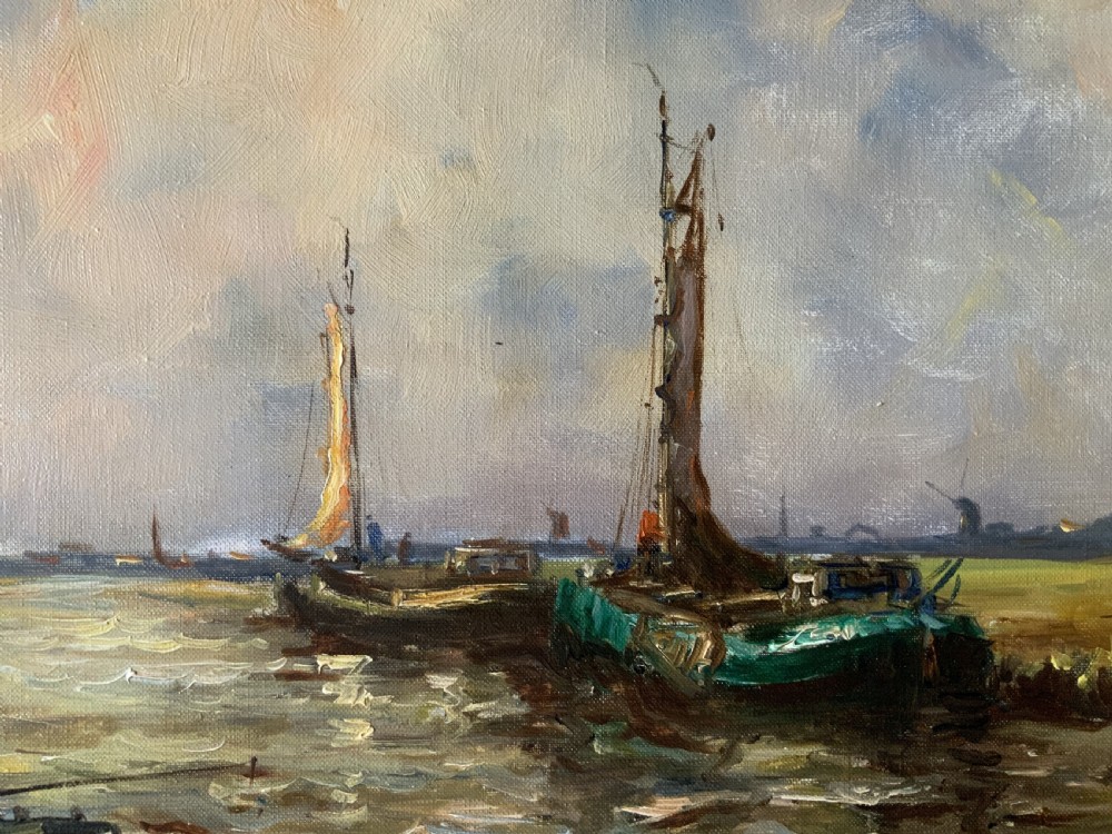 An impressionistic Dutch canalscape oil painting depicting traditional barges alongside a grassy riverbank, housed in an ornate carved gold frame. View IX