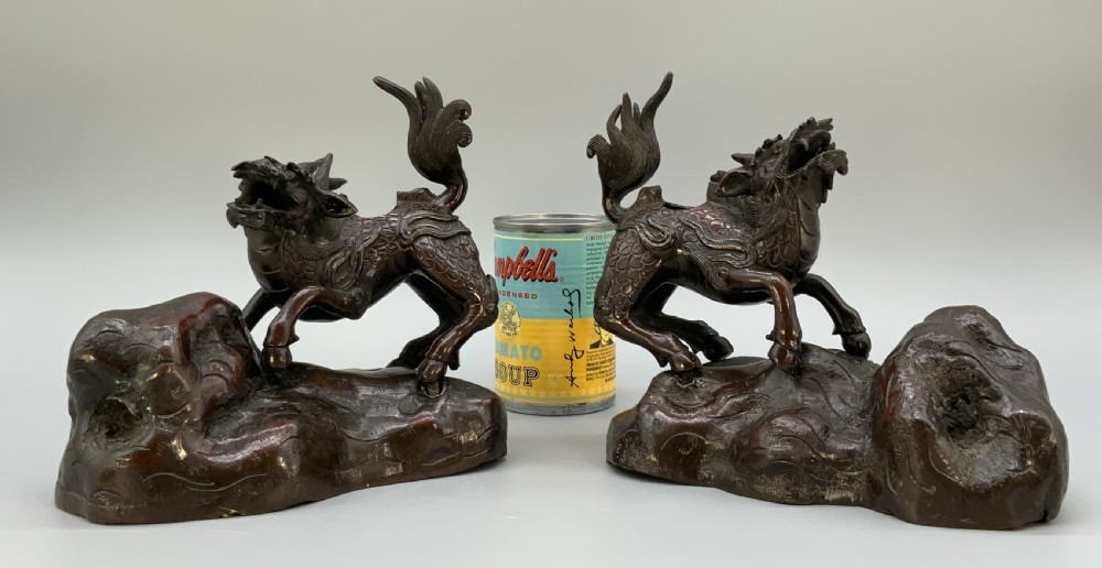 A pair of patinated dark bronze Japanese mythical creature statues positioned on sculpted rocky bases. View III