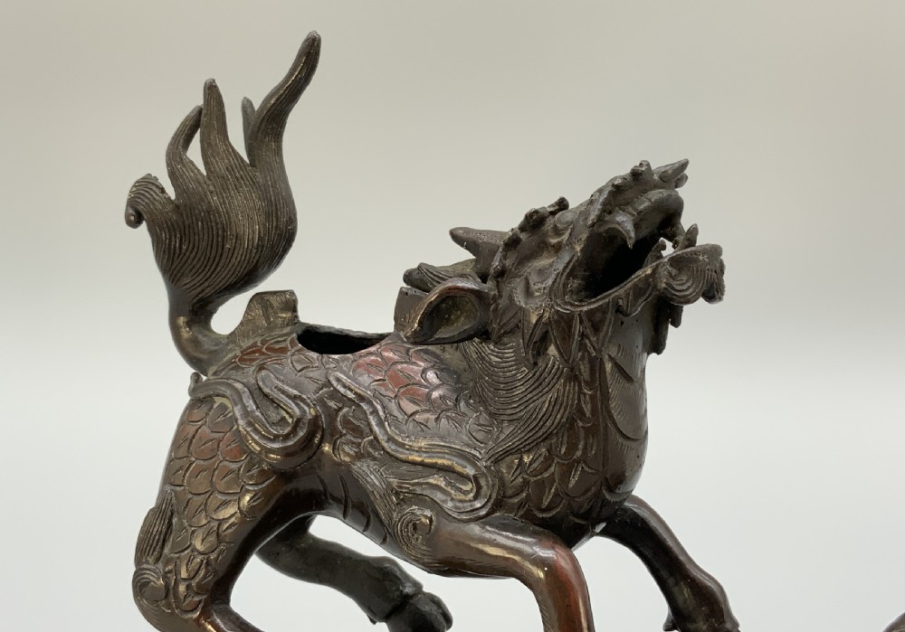 A pair of patinated dark bronze Japanese mythical creature statues positioned on sculpted rocky bases. View XIII