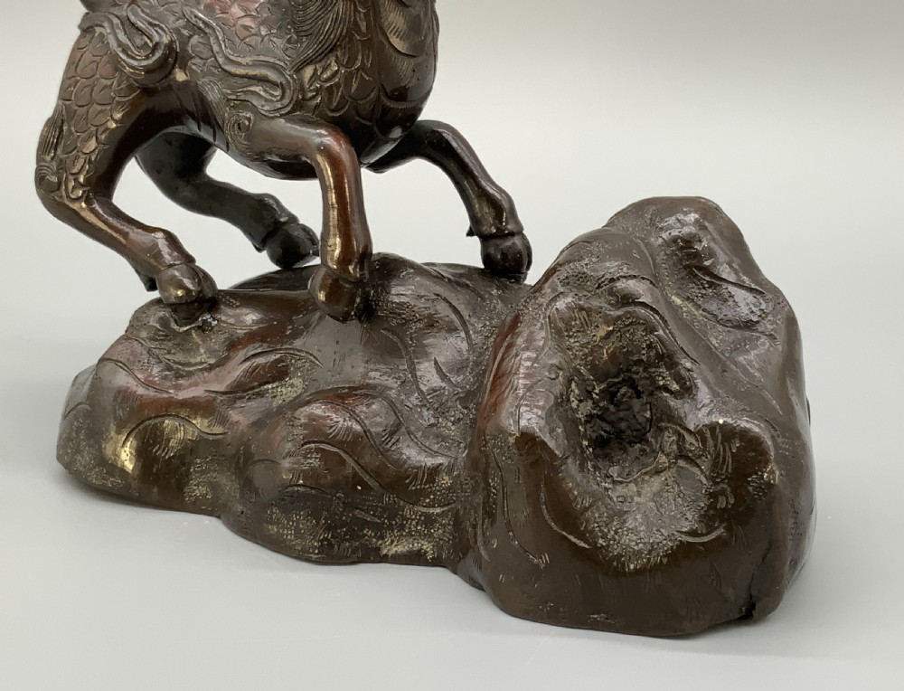 A pair of patinated dark bronze Japanese mythical creature statues positioned on sculpted rocky bases. View XIV