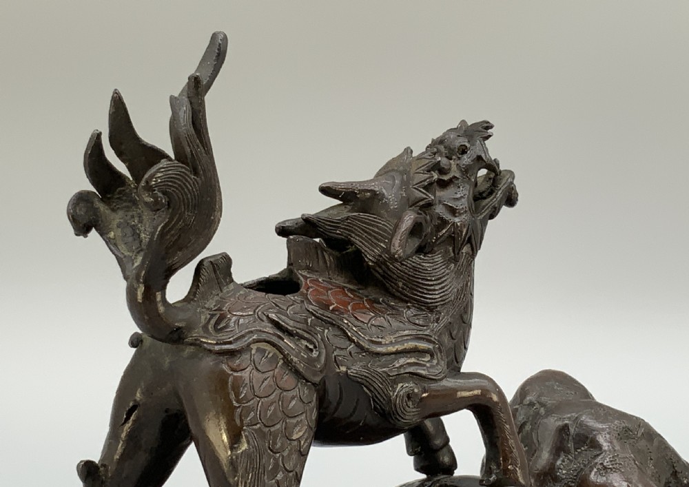 A pair of patinated dark bronze Japanese mythical creature statues positioned on sculpted rocky bases. View XV