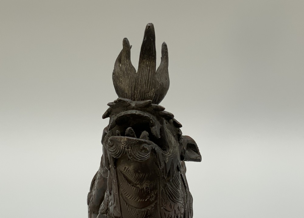 A pair of patinated dark bronze Japanese mythical creature statues positioned on sculpted rocky bases. View XVII