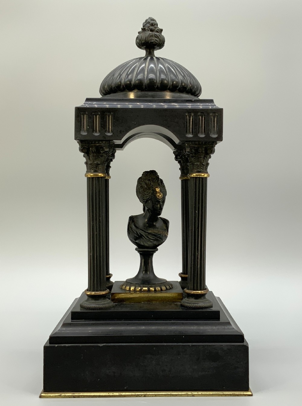 A 19th-century patinated bronze and black marble classical domed temple featuring fluted columns and a central classical bust.