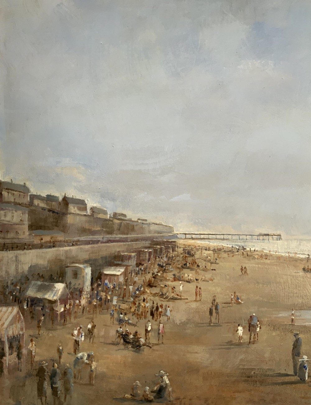 An impressionist oil painting on board depicting a crowded British seaside beach with a pier in the distance, housed in a gilt frame with a fabric liner. View VII