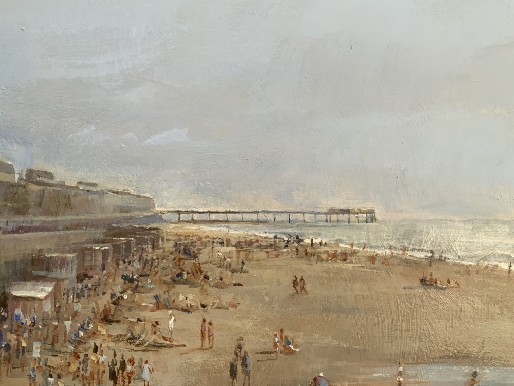An impressionist oil painting on board depicting a crowded British seaside beach with a pier in the distance, housed in a gilt frame with a fabric liner. View IX