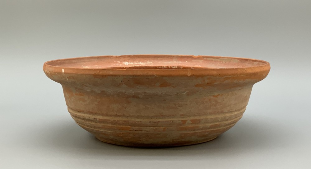 A pair of circular Han Dynasty red terracotta pottery basins featuring broad everted rims and horizontal exterior grooves. View V