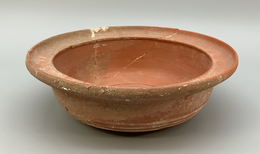 A pair of circular Han Dynasty red terracotta pottery basins featuring broad everted rims and horizontal exterior grooves. View X
