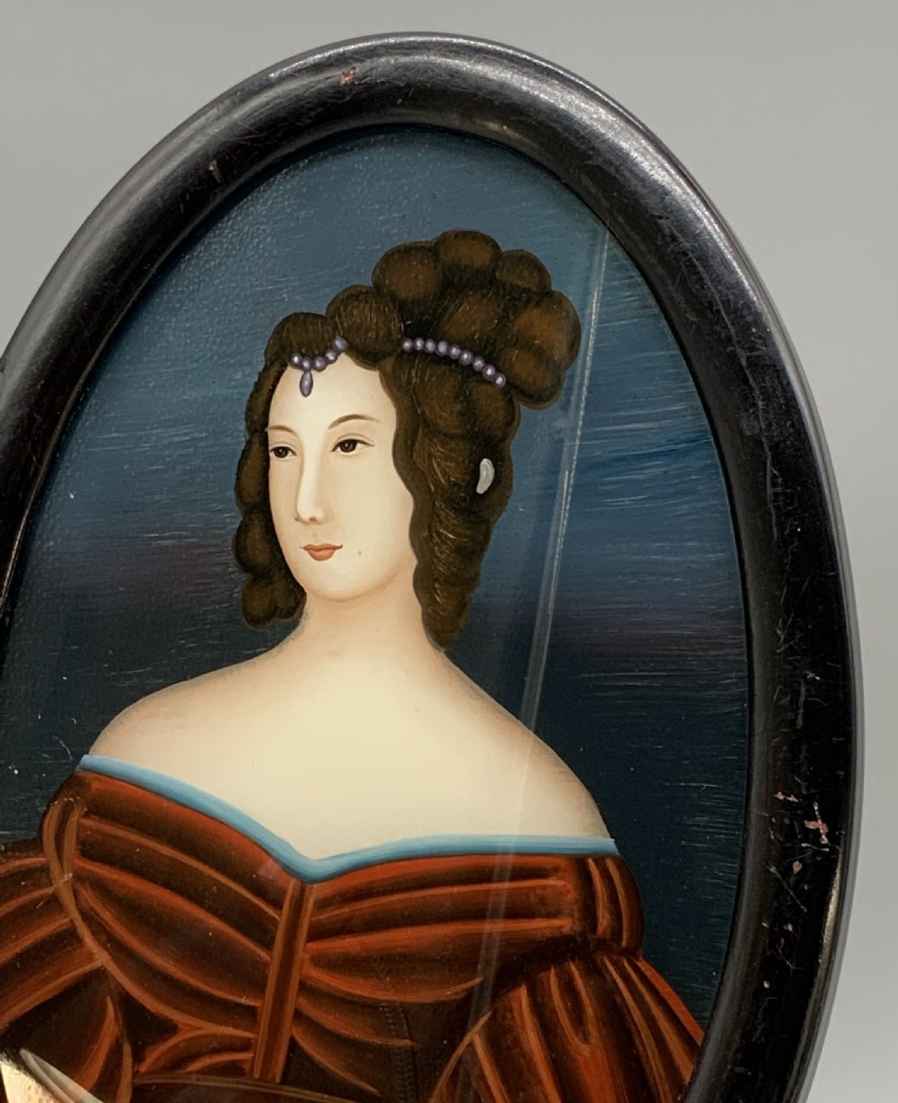 A pair of Japanese Meiji period miniature portrait paintings in oval dark rosewood frames, depicting women in 19th-century style dresses. View V