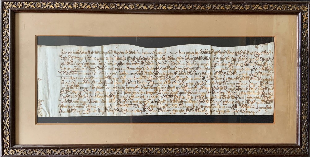 A framed 17th-century handwritten vellum document featuring brown ink calligraphic script presented in an ornate dark wood frame.