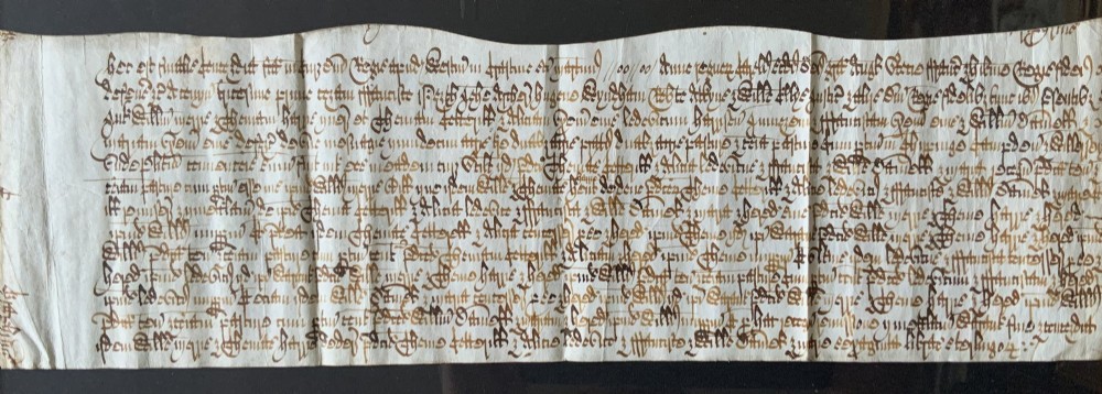 A framed 17th-century handwritten vellum document featuring brown ink calligraphic script presented in an ornate dark wood frame. View III