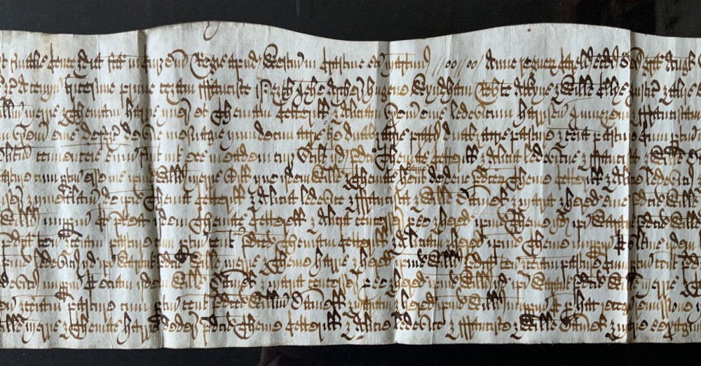 A framed 17th-century handwritten vellum document featuring brown ink calligraphic script presented in an ornate dark wood frame. View V