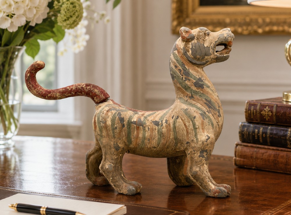 A painted earthenware figure of a tiger-like mythical beast from the Han Dynasty featuring an arched neck, raised tail, and red and green painted stripes. View II