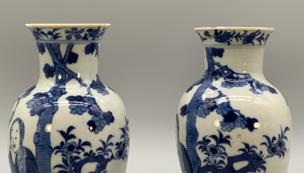 A pair of flared Chinese blue and white porcelain vases hand painted with figural court ladies amidst floral motifs. View V