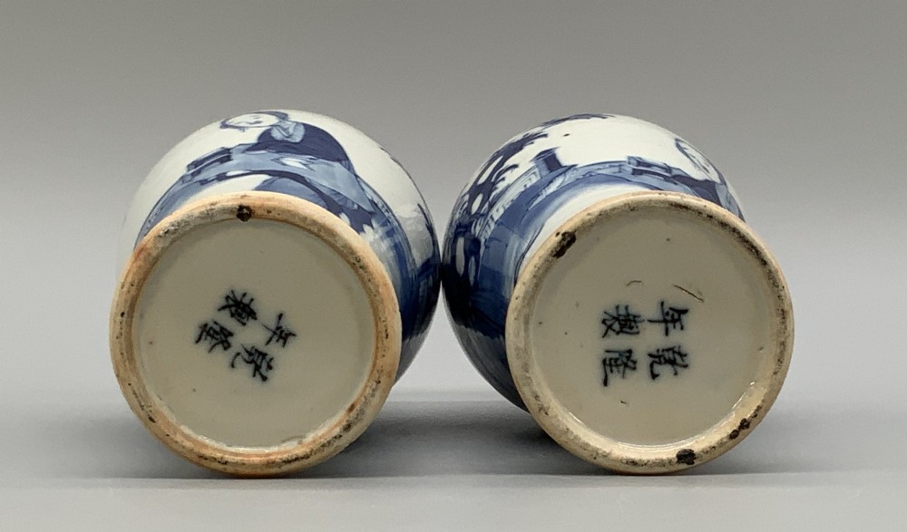 A pair of flared Chinese blue and white porcelain vases hand painted with figural court ladies amidst floral motifs. View X