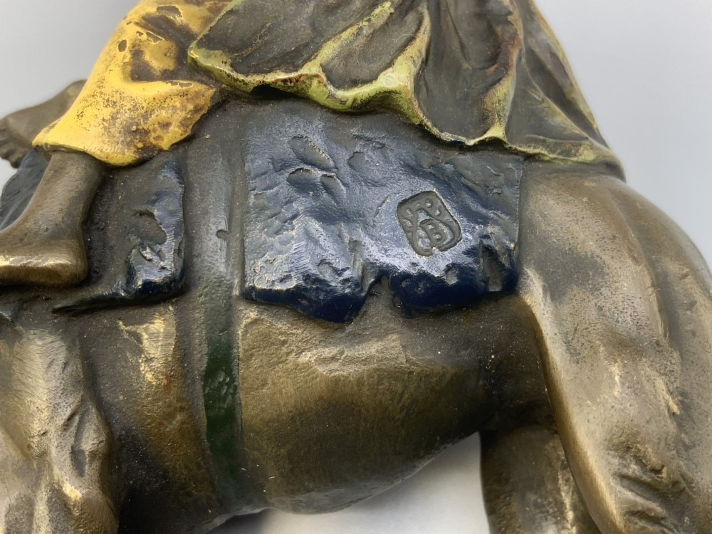 An Austrian cold-painted bronze sculpture depicting a turbaned Arab rider holding a rifle while seated atop a standing camel. View XIV