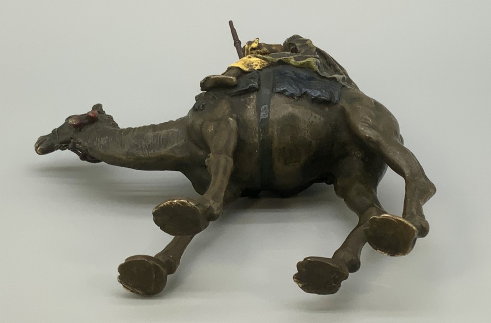 An Austrian cold-painted bronze sculpture depicting a turbaned Arab rider holding a rifle while seated atop a standing camel. View XV