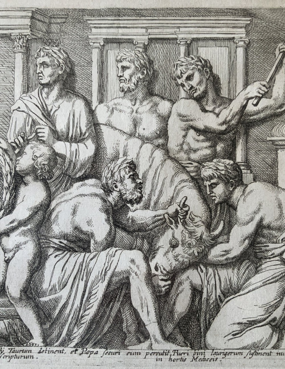 A monochrome 17th-century classical etching depicting men and boys performing a ritual sacrifice of a bull in front of a Roman temple, complete with Latin text at the bottom. View XI