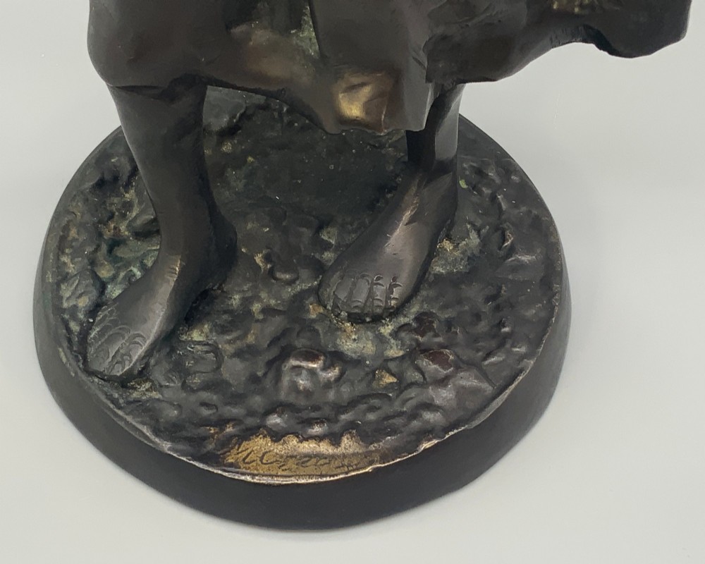 An antique dark bronze sculpture of a young maiden wearing a draped apron dress, standing barefoot on a rounded integral base. View XIII