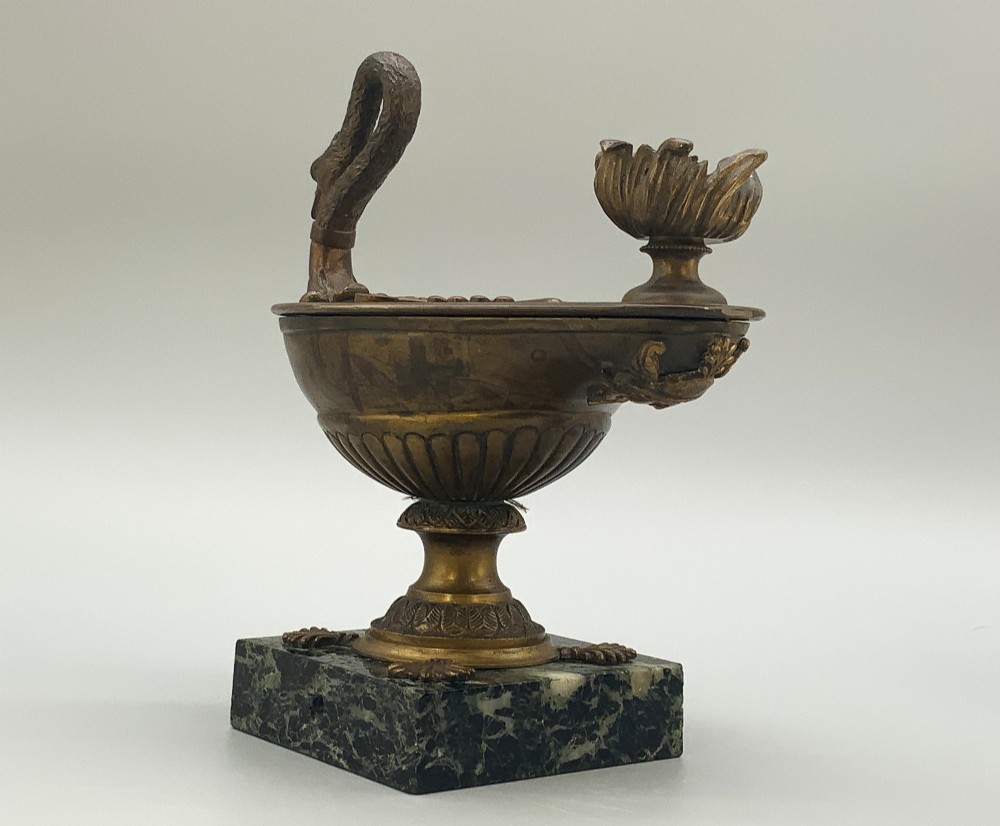 A nineteenth-century Grand Tour patinated bronze oil lamp featuring a serpent handle and gadrooned body, mounted on a square green marble base. View VIII